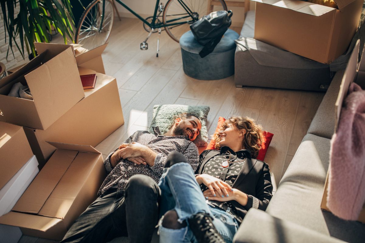  junges paar liegt in neuer wohnung auf dem boden 