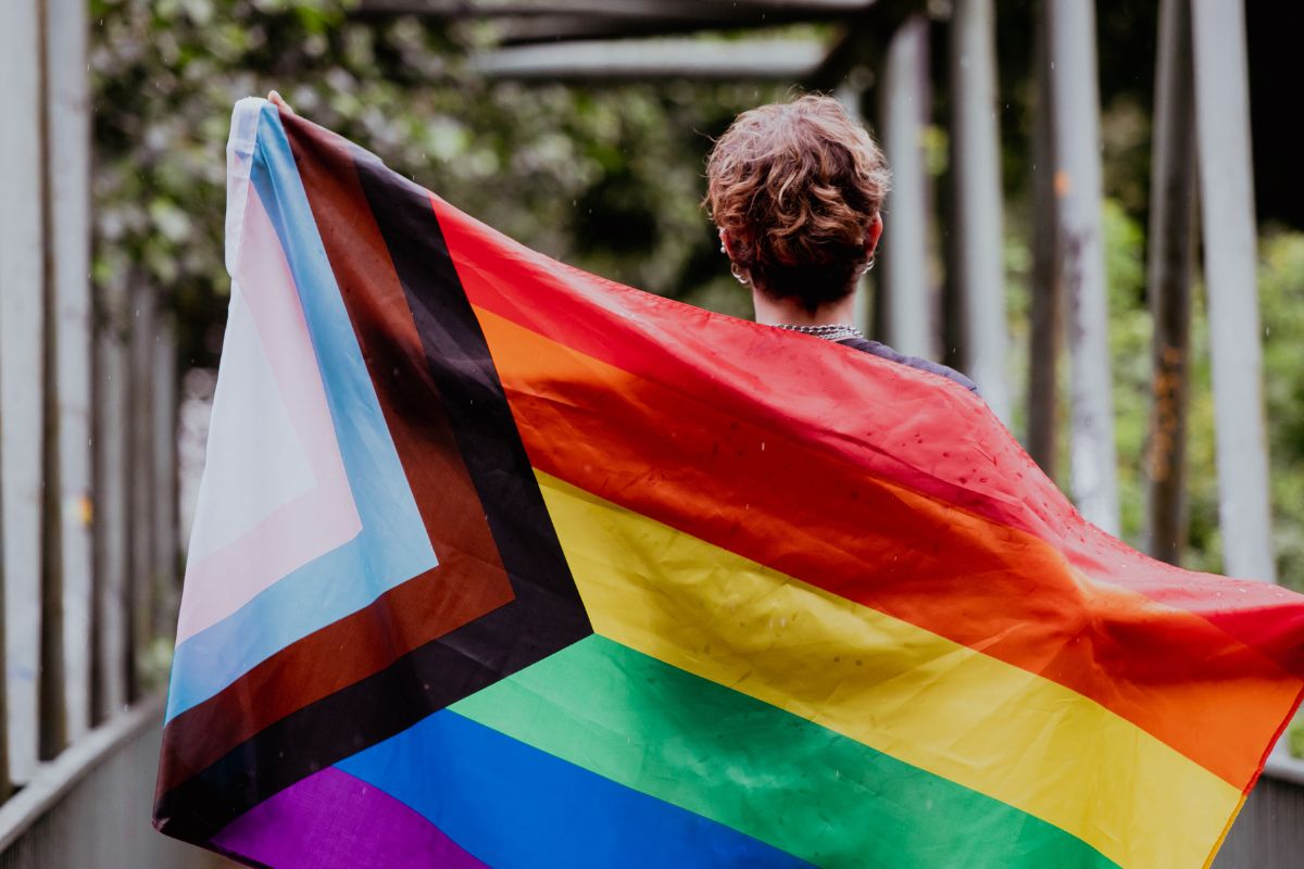  person mit queer pride flagge 