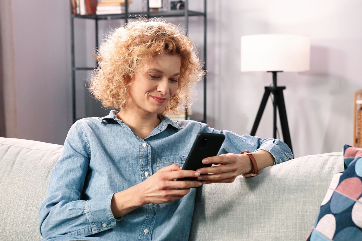  Eine Frau liest auf ihrem Smartphone 