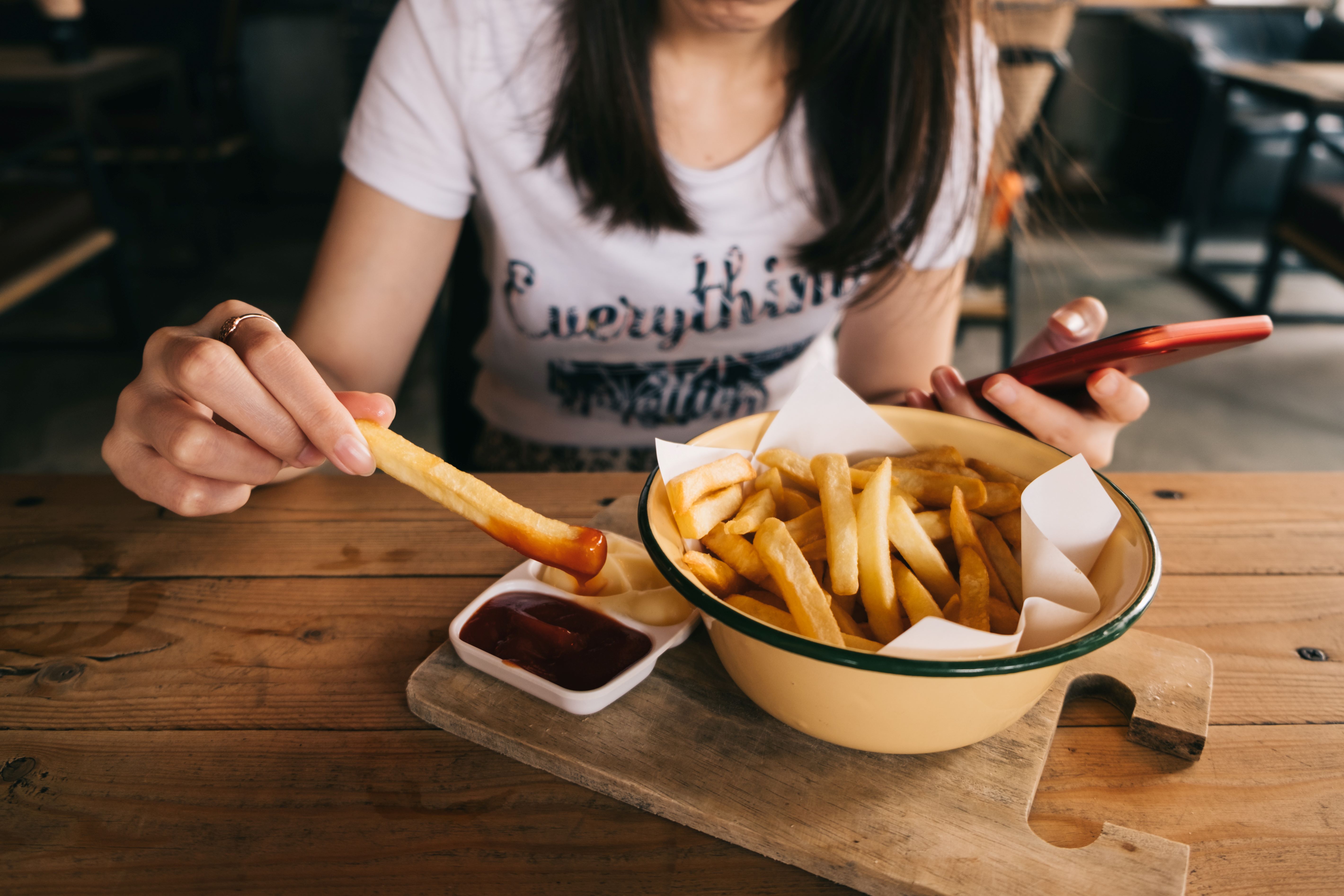  Frau isst Fritten mit Mayo und Ketchup 