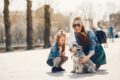 Mutter und Tochter mit Hund im Park